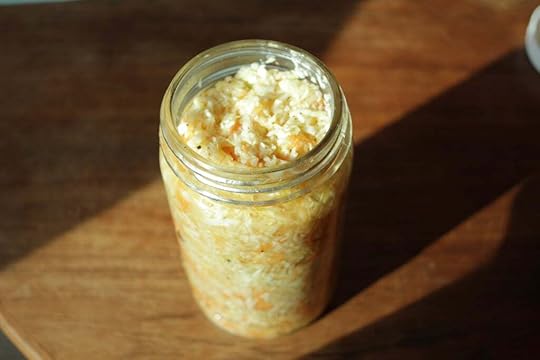 The uncapped jar of health salad, sitting in a sunbeam.