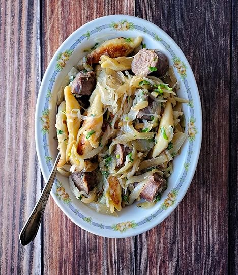 A platter of shupfnudeln, German dumplings, with sausages, onions and sauerkraut.