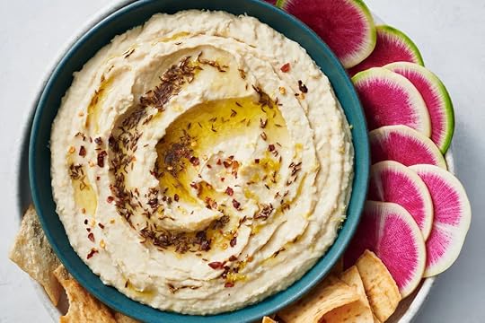 White bean dip with cumin oil in a green bowl