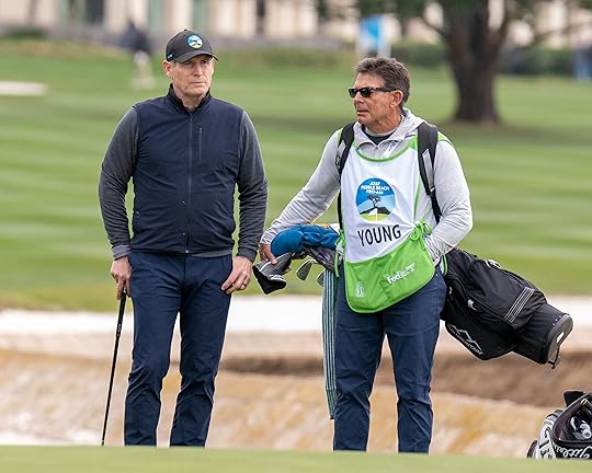 Steve Young, former NFL quarterback, talks with his caddie on...