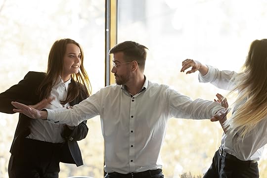 Man standing in between to women fighting
