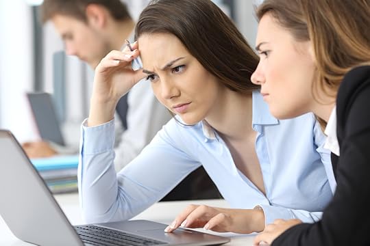 Two women looking at a laptop, concerned
