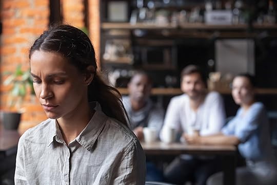 Woman with her back to her team looking pensive