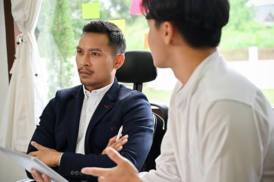Two colleagues one with arms crossed acting passive-aggressively