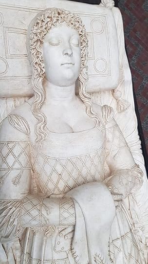 Beatrice d'Este's tomb. She is carved in white marble, lying as if sleeping serently on a bed. She wears a gown elaborately patterned with diamond stripes, and her hair is curled in a halo around her forehead.