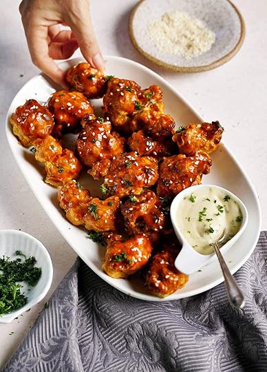 hand grabbing a vegan Buffalo cauliflower wing as Superbowl snack
