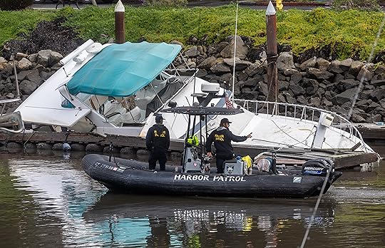 A Santa Cruz Harbor Patrol crew passes by a damaged...