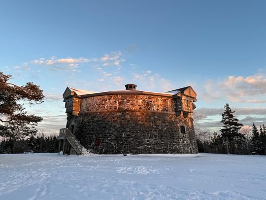 Round Martello tower, snow, trees, blue sky