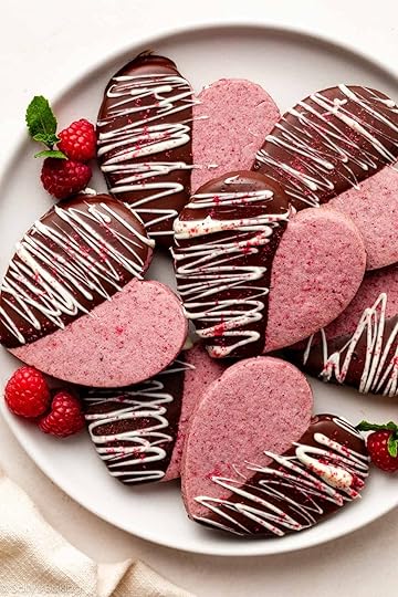 heart-shaped raspberry sugar cookies dipped in chocolate and white chocolate on white plate.