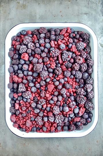 A medley of frozen berries in a white enamel pan.