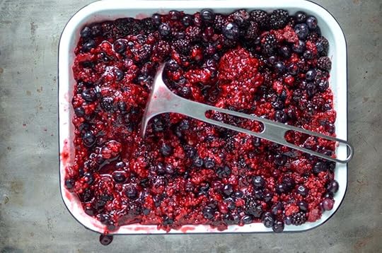 Mashed berries in a white enamel baking tin.
