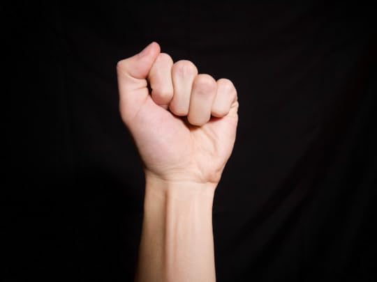 An upraised fist against a black background