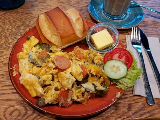 Scrambled eggs with vegetables, a bread roll and two slices of dark bread