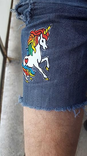 Pictured: Close-up of a Rainbow Unicorn patch sewn to a pair of jeans shorts.