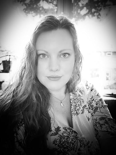 white woman, black and white photo, light coloured long wavy hair and floral patterned shirt.