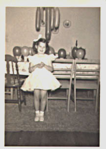 child standing in front of a birthday table