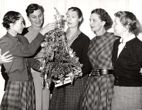 A group of women standing around a christmas treeDescription automatically generated