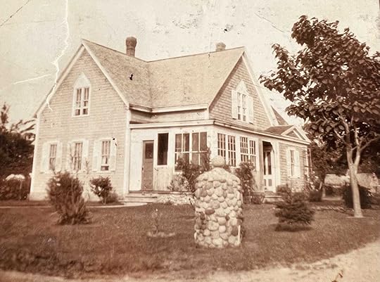 A house with a stone pillar in front of itDescription automatically generated