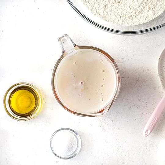 Foamy, frothy yeast water in a liquid measuring cup.