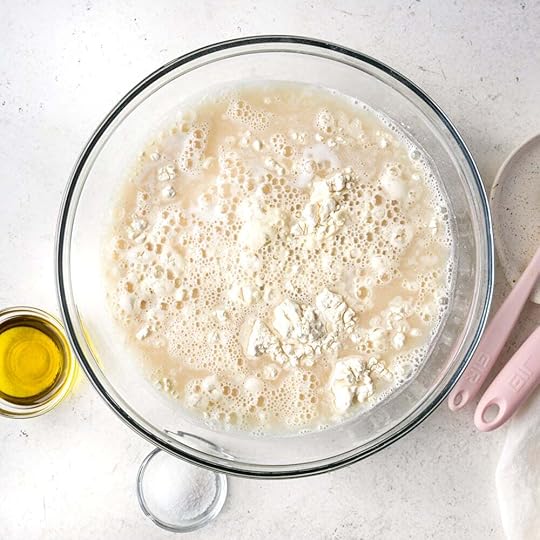Bubbly yeast with flour in a glass bowl.