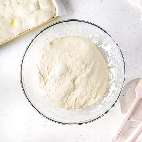 Happy, puffy focaccia dough resting in a glass bowl.