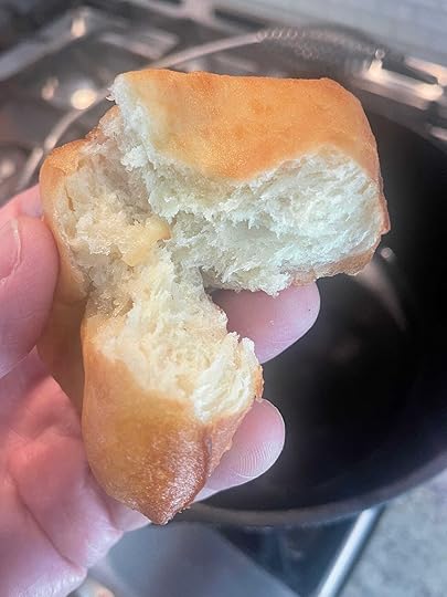 Fastnacht held in hand, torn open to show white interior crumb.