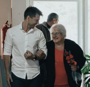 Young man smiling down at gray-haired woman