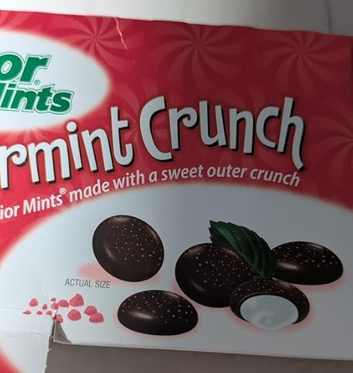 The packaging for box of Junior Mints that shows the candies as having little red freckles on them.