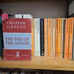hardback of The End of the Affair on shelf with vintage orange Penguin editions of Graham Greene