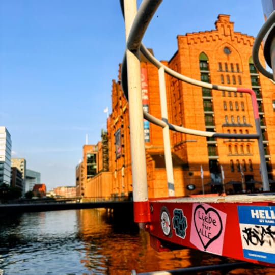 Hafencity, Blick über Wasser auf die Rückseite des Maritimen Museums, im Vordergrund ein Aufkleber an einem Metallgestänge: 