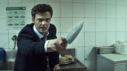 Jack Quaid wearing a suit and holding a knife in Novocaine