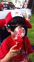 Young boy on Canada day with sun glasses, hat, toy, and accessories