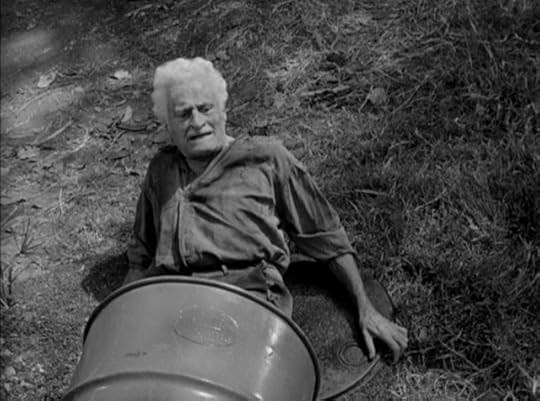 An old man crawls out of a barrel