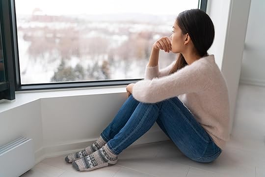 Image of an anxious woman sitting on the floor looking out a window. If your emotions are causing you distress, an adult IOP in Houston, TX can help you begin to cope and overcome them.