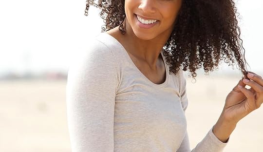 Image of a smiling African American woman standing outside twirling her hair on a sunny day. With the help of DBT at an Adult IOP in Houston, TX you can begin to learn effective coping skills to manage your intense emotions.