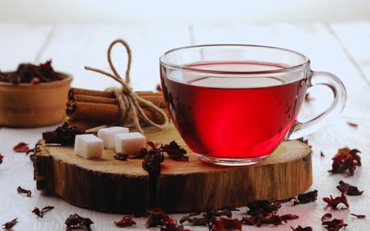 glass teacup filled with red hibiscus tea