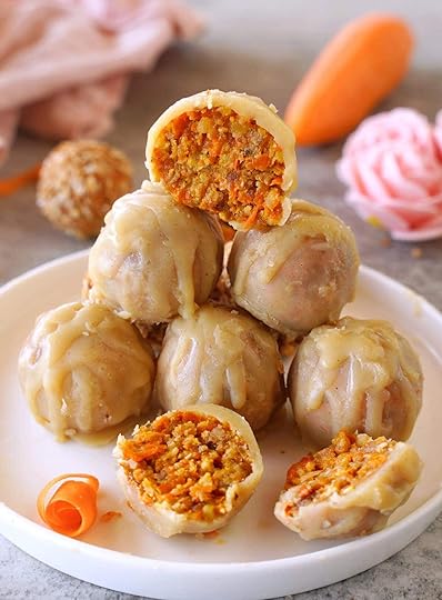 stack of several carrot cake balls covered in white chocolate on white plate