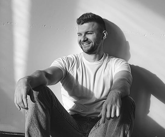 Black and white image of a happy man sitting on the ground resting against a wall. Learn to manage your BPD symptoms in positive ways with the support of an adult IOP in Houston, TX.