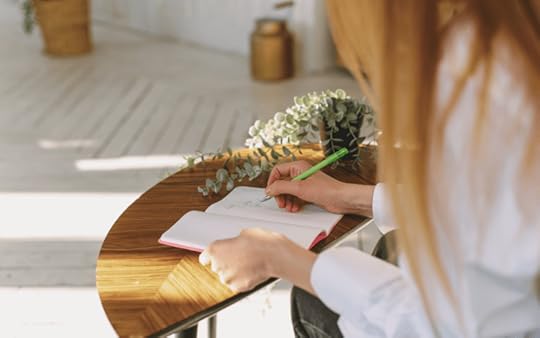 woman sitting a desk and writing
