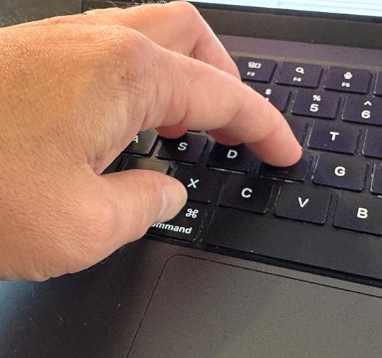 Photo of my left hand on the keyboard of a MacBook Pro. My forefingers are on the homerow and my thumb is moved slightly under my hand to be on top of the Cmd key