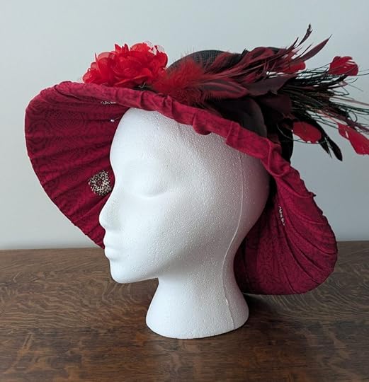 mannequin wearing hat with silk lining, feathers, and flowers