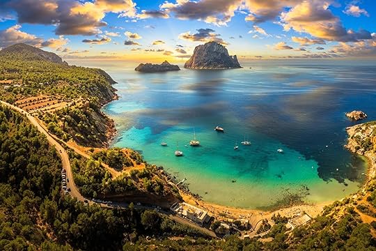 Aerial view of Cala d’Hort beach in Ibiza, featuring the iconic Es Vedrà rock, turquoise waters, and scenic Mediterranean coastline