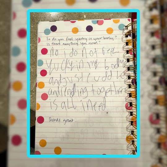 A close-up of an open spiral notebook with a colorful polka dot border. The page contains a handwritten response to a prompt that asks, “Do you feel yucky in your body? Is there anything you need.” The response says: “No I do not feel yucky in my body and just cuddle and reading together is all I need.” The final response says, “Sounds great”