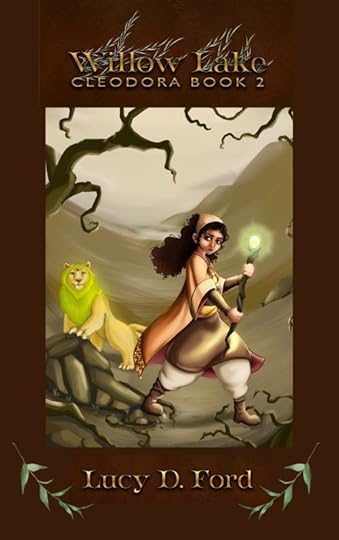 A young girl in orange robes advances from a dusty beige landscape. She has curly black hair and holds a glowing staff. Beside her is a yellow bobcat with a green mane. The image is framed in dark brown with a metallic gold headline. Text reads 