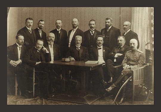 Portrait of a group of 12 men around a desk who are members of a Russian zemtsvo in 1913 before the Revolution. They are in formal suits and ties.