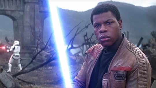 John Boyega wields a lightsaber as Finn in Star Wars: The Force Awakens.
