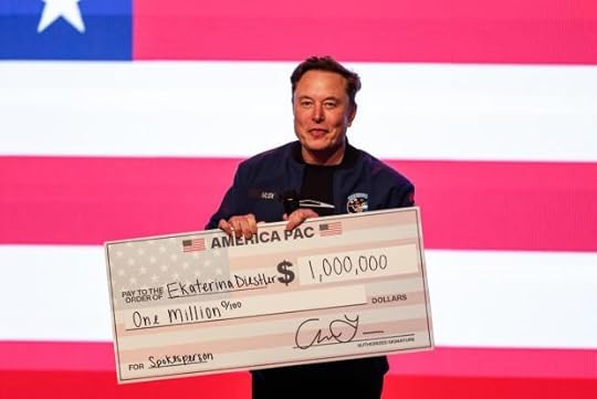 Elon Musk speaks at a town hall holding a check