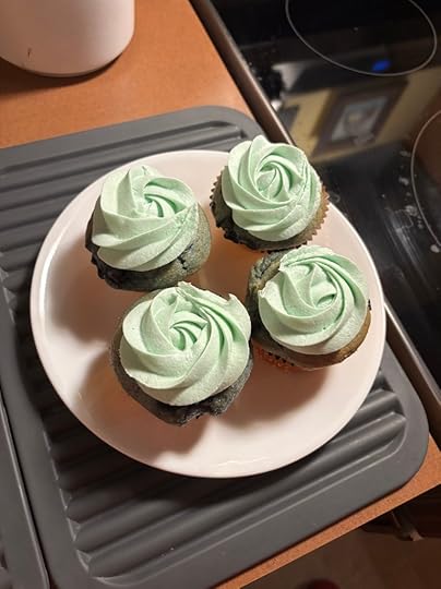 Four blueberry cupcakes with seafoam green buttercream rosettes