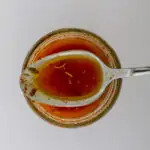 spoonful of basic vinaigrette resting on jar of dressing.