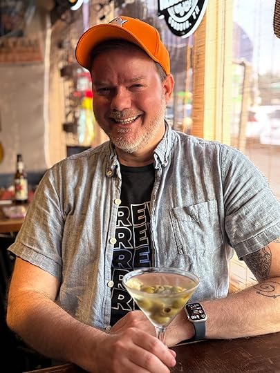 a man wearing a hat and holding a martini glass
